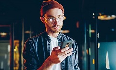 Man looking at phone for ways to save on a low income.