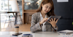 Smiling woman looking at the benefits of online banking on a tablet